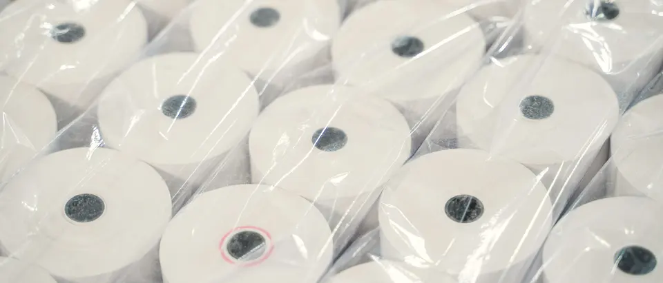 Gestapelte Bonrollen aus Thermopapier, einzeln in Folie verpackt.